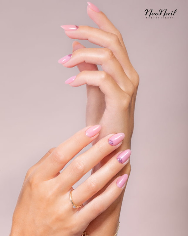 Manicure hybrydowy do pracy w delikatnym, różowym kolorze z subtelnym akcentem.